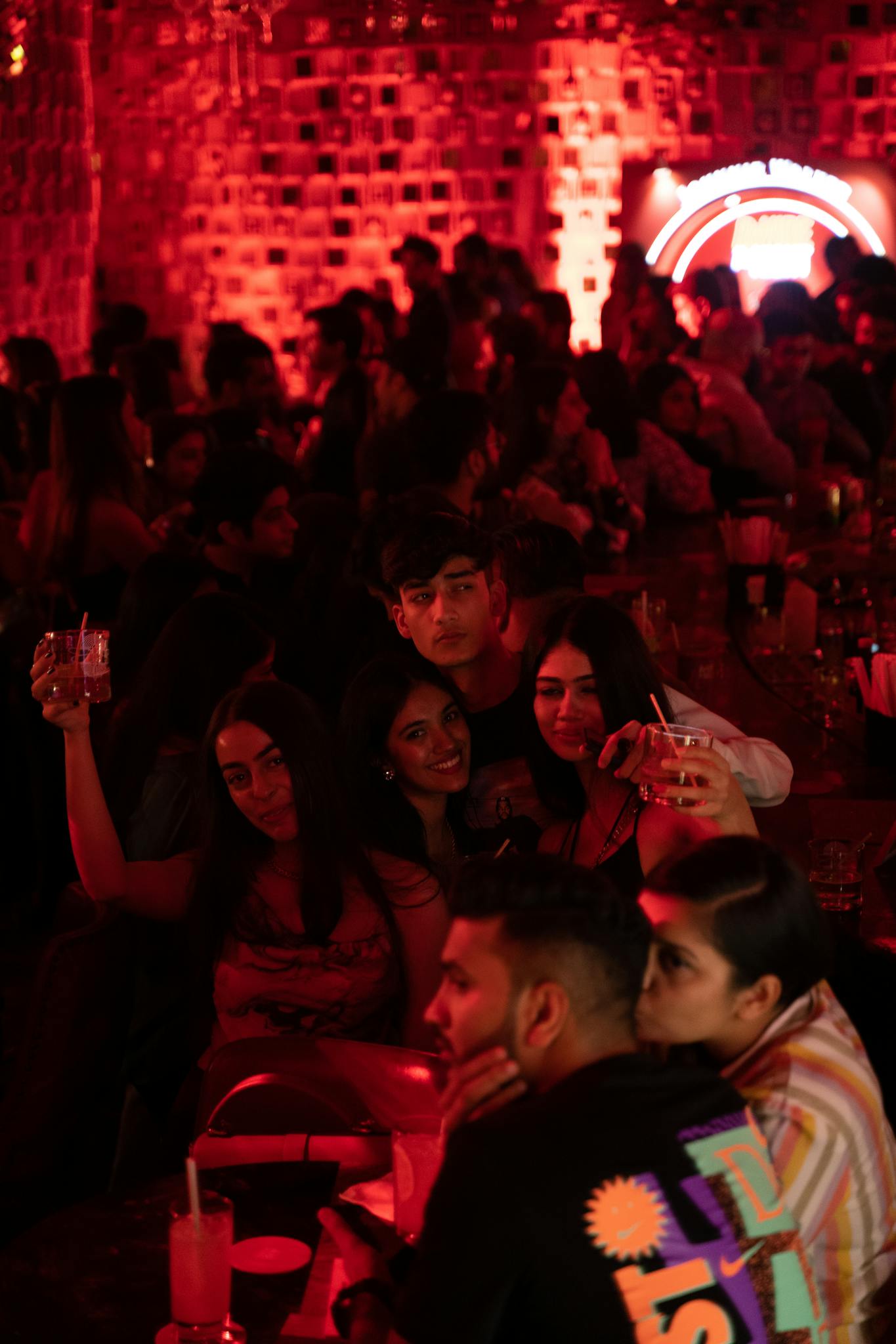 A lively indoor club scene with friends enjoying drinks and a vibrant atmosphere.